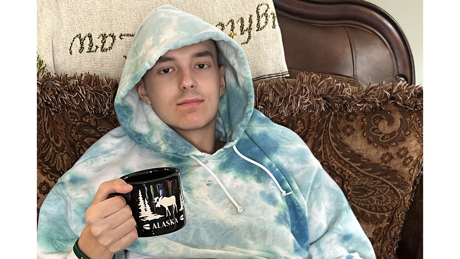 Joey Edwards sipping tea while he wears a hoodie